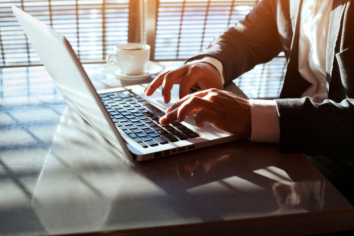 man typing at laptop